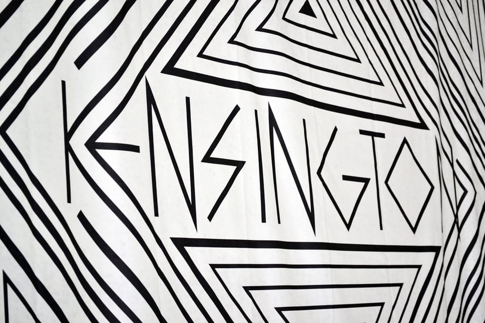 Close-up van een textielbackdrop met een zwart-wit grafisch bandlogo