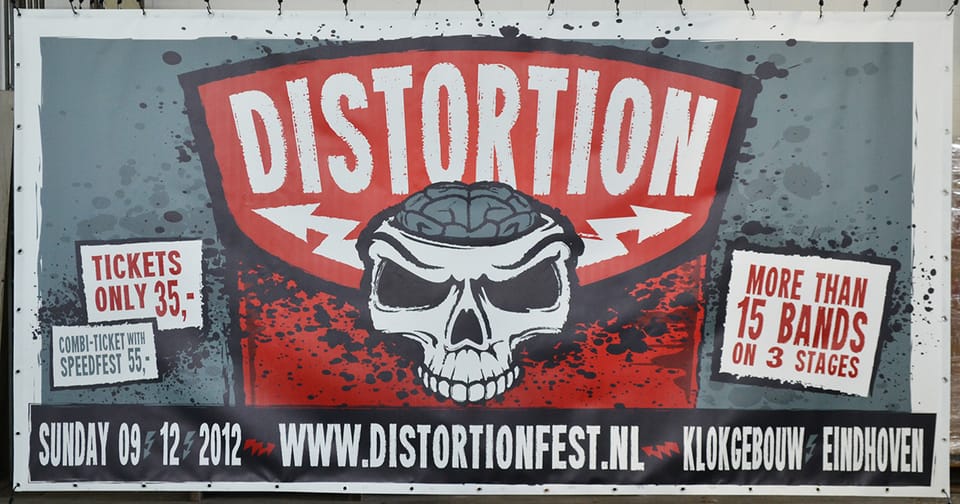 Bedrukt spandoek met een festivalaffiche en ringen, gespannen aan een hekwerk