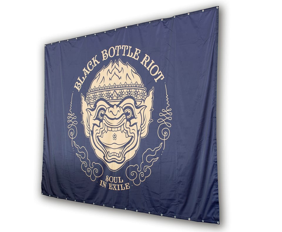 Donkerblauw heavytex-doek met een goudkleurig masker-logo, losjes opgehangen