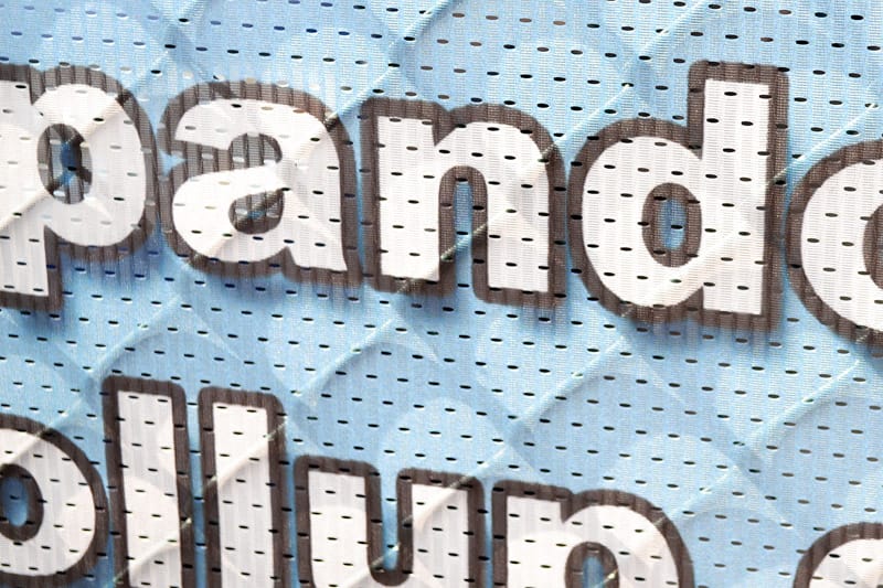 Close-up van polymesh: bedrukte letters op doek met kleine perforaties