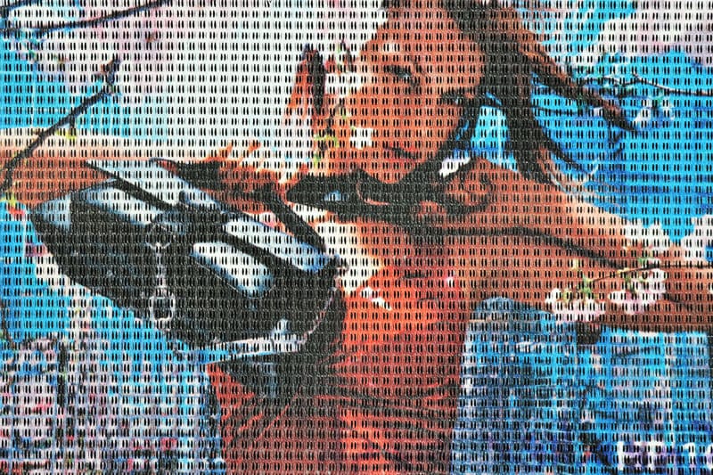 Bedrukt speaker-mesh met een kleurrijke foto, de open structuur zichtbaar door het beeld heen