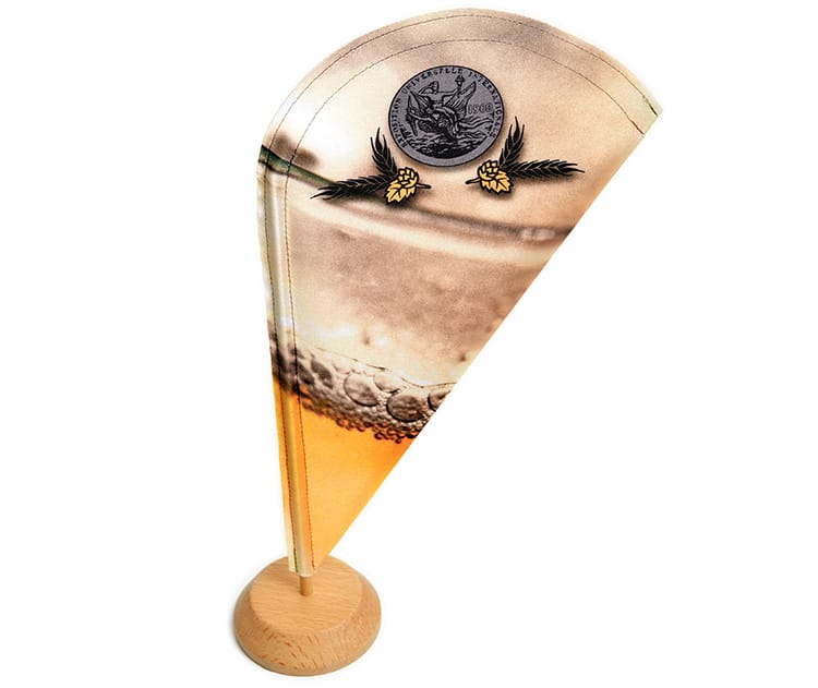 Tafelvlag in druppelvorm met een bierglas en logo op een houten voet