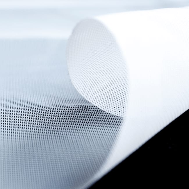 Wit voile-doek met fijne, open weefstructuur, in een zachte golf gelegd