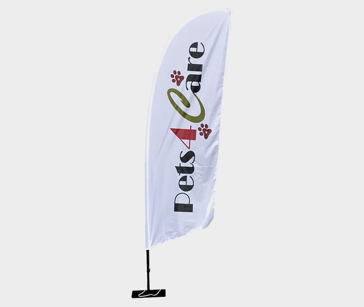 Witte beachflag in vleugelvorm met zwart en rood logo, op een grondplaat