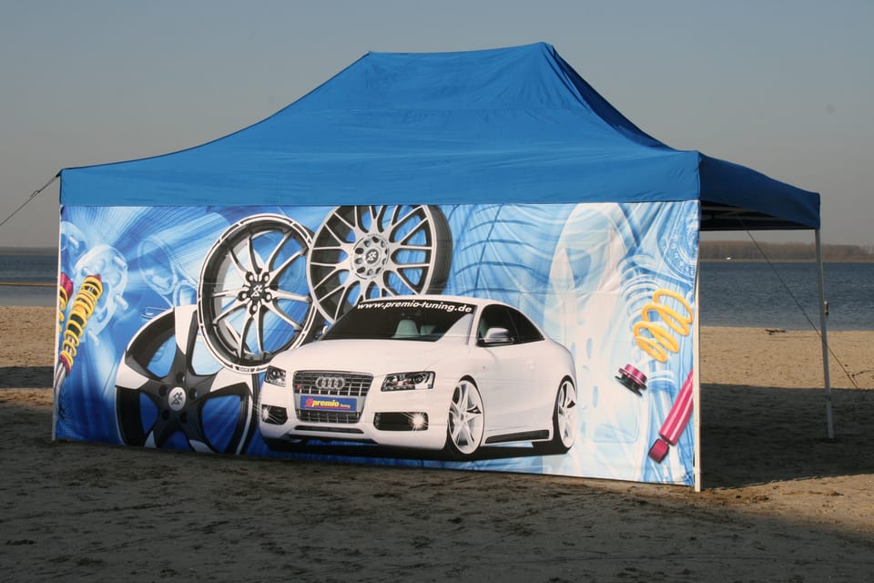 Blauwe vouwtent van 3 × 6 m op het strand, met een full colour bedrukte zijwand