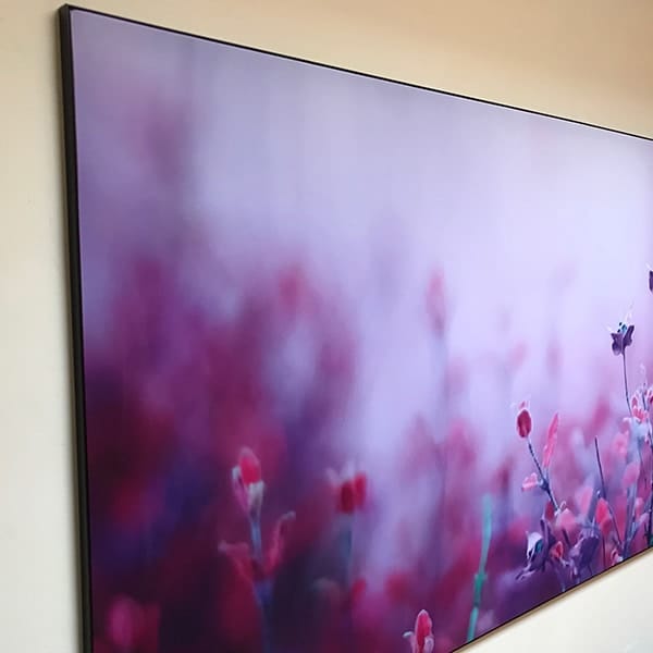 Stretchframe met paarse bloemenfoto aan een lichte wand